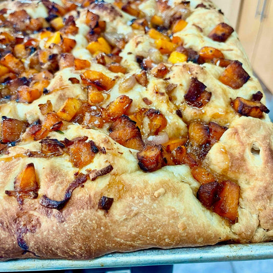 Butternut squash caramelized shallot and hot honey focaccia with golden squash chunks and olive oil bread