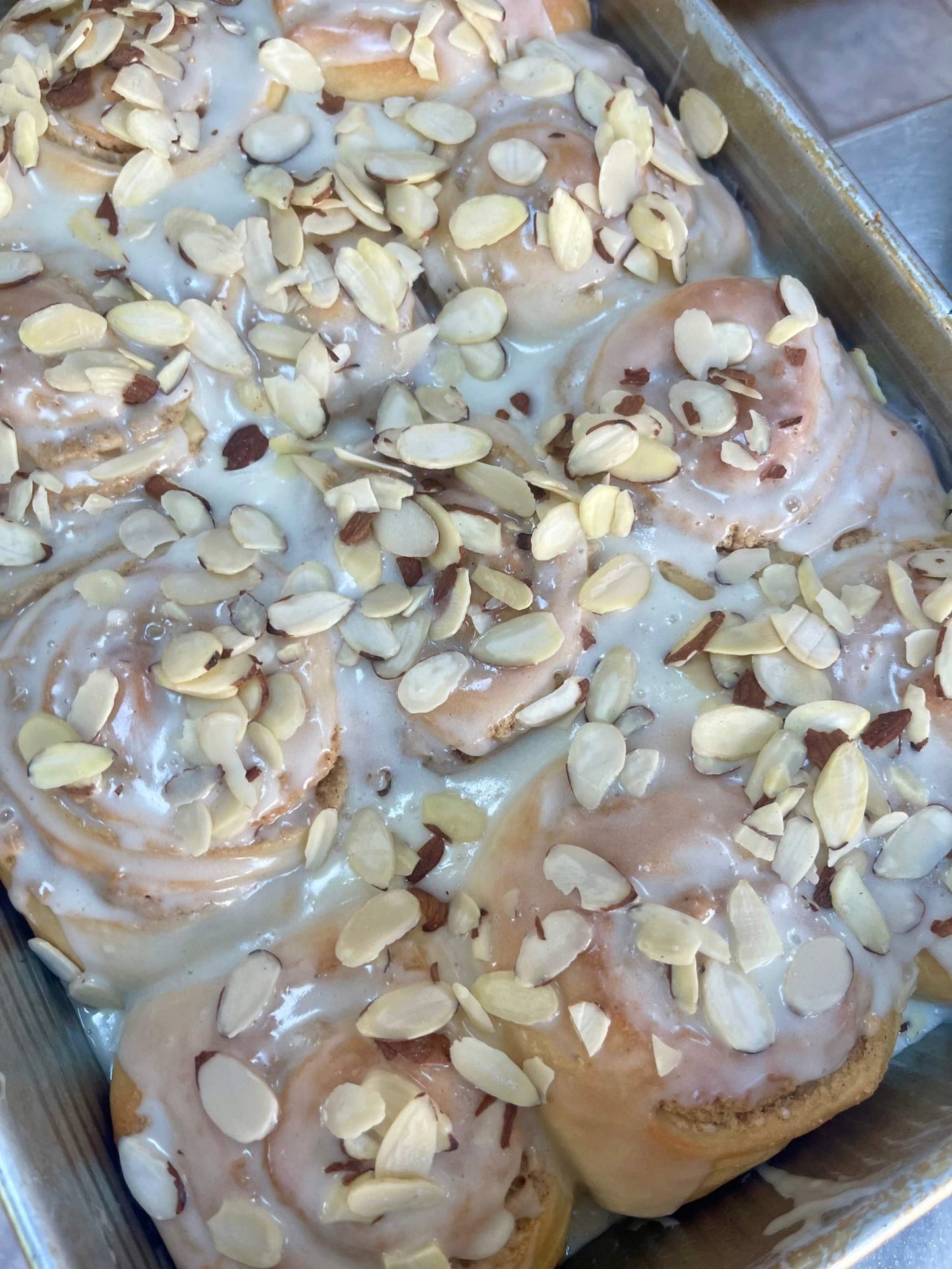 Box of 4 almond croissant cinnamon buns with almond icing and sliced almonds, rich dessert or breakfast treat