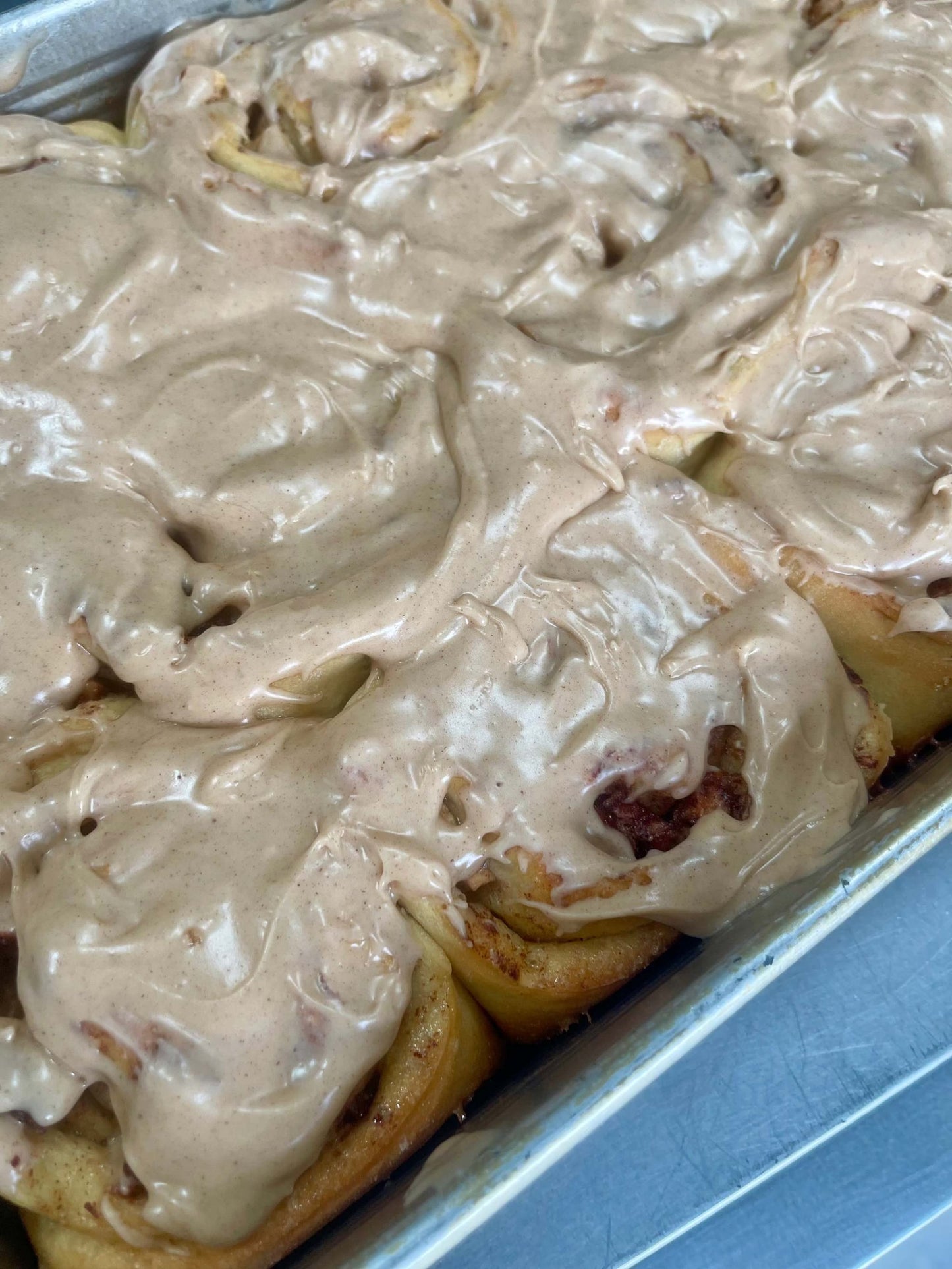 Apple cider cinnamon buns with frosting in a box