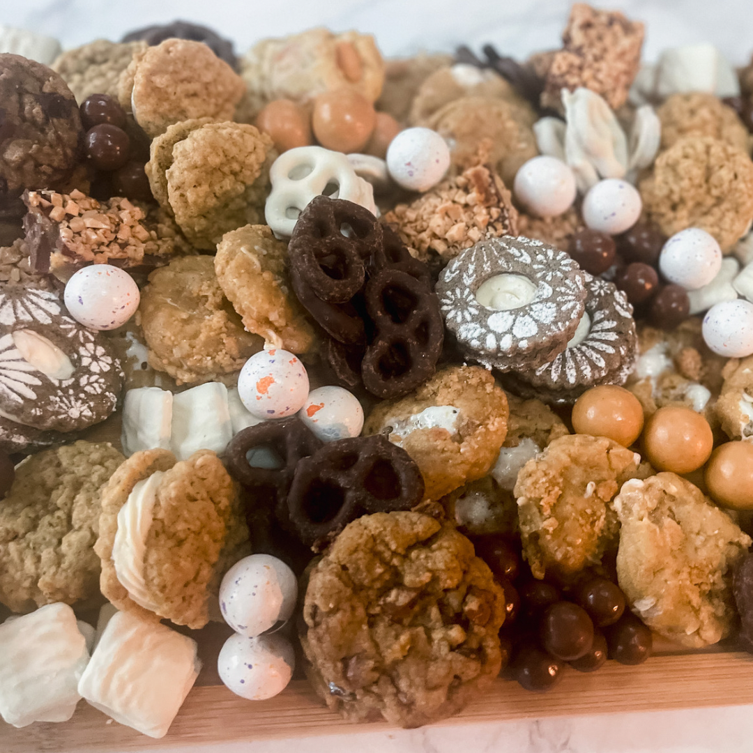 CPB Signature Cookie Board with assorted cookies including brown butter chocolate chip, oatmeal sandwich, coffee toffee bar, and banana pudding on a dessert board