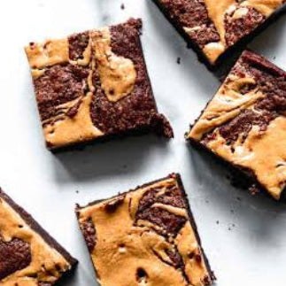 Close-up of fudgy peanut butter swirl brownies in a box with four pieces