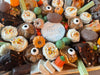 Halloween Dessert Board with spooky themed cookies, cupcakes, brownies, pumpkin decorations, and "Happy Halloween" cake centerpiece