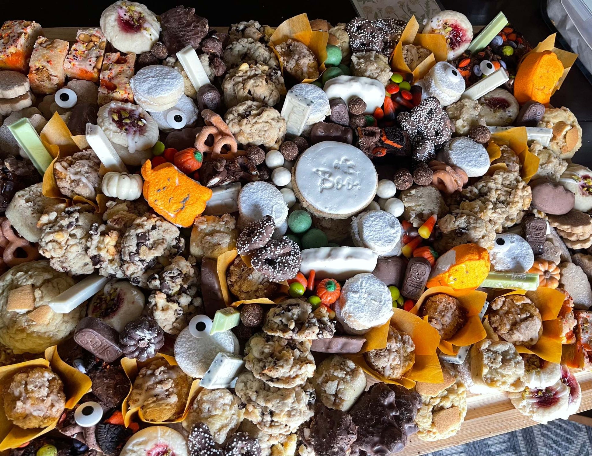 Halloween Dessert Board with assorted spooky cookies, brownies, cakes, and seasonal treats on a wooden platter