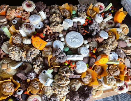 Halloween Dessert Board with assorted spooky cookies, brownies, cakes, and seasonal treats on a wooden platter