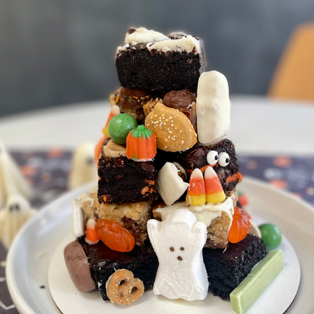Halloween Brownie Tower with assorted brownies, Halloween candies, and ghost marshmallow decoration on a plate