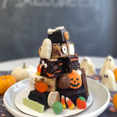 Halloween Brownie Tower with assorted festive brownies and Halloween candy on white plate