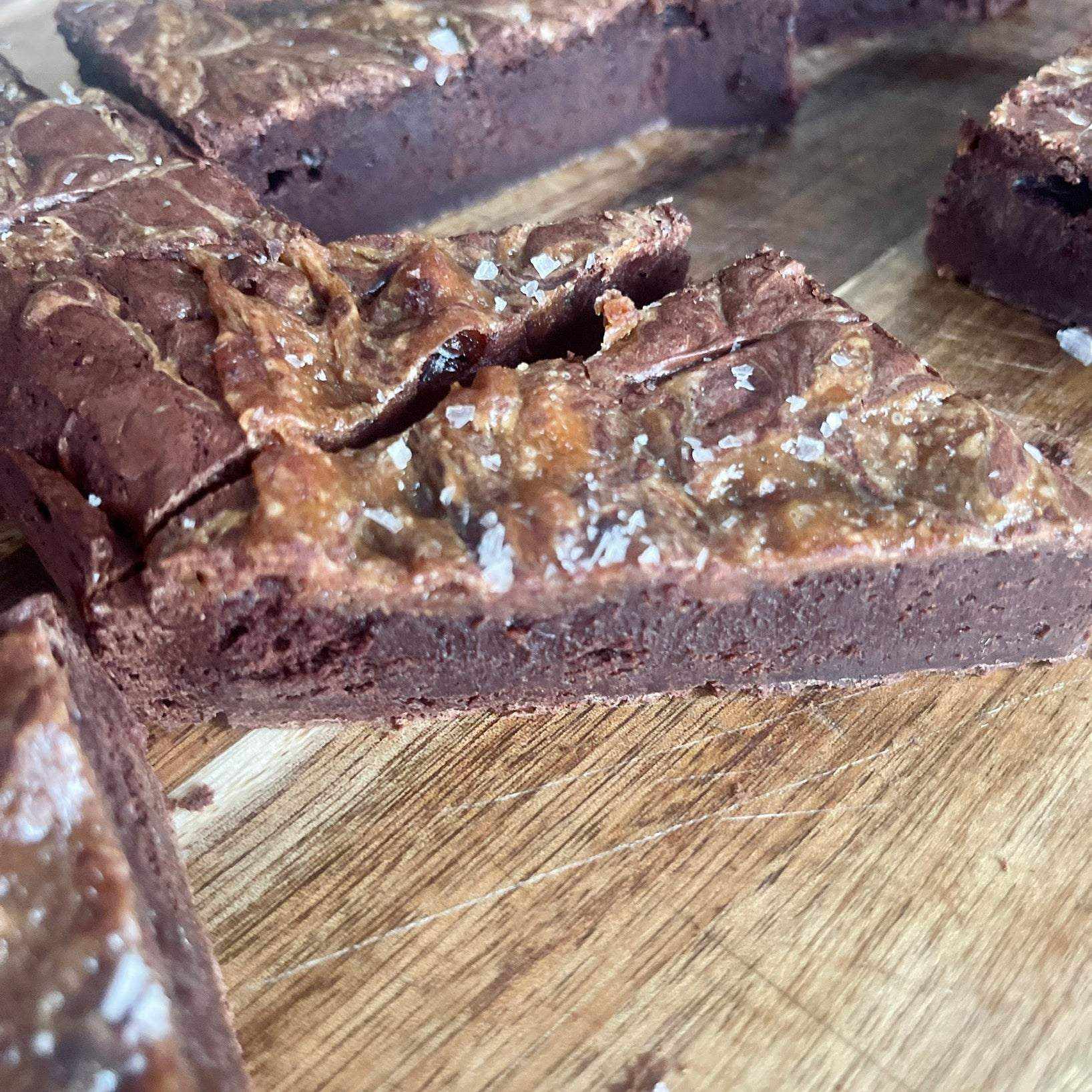 Flourless Dulce de Leche Swirl Brownie with caramelized milk swirl and flaky salt topping in a box of eight pieces