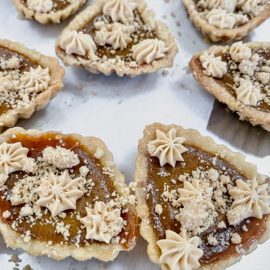 Thanksgiving Pumpkin Biscoff Tartlets with spiced pumpkin filling, Biscoff shortbread crust, cookie butter caramel, cream, and cookie crumble topping