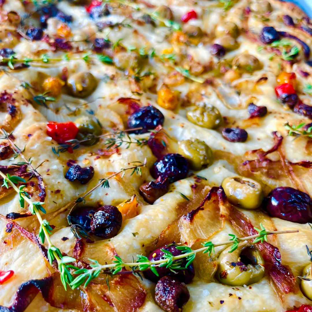 Olive caramelized onion focaccia with colorful olives on olive oil flatbread