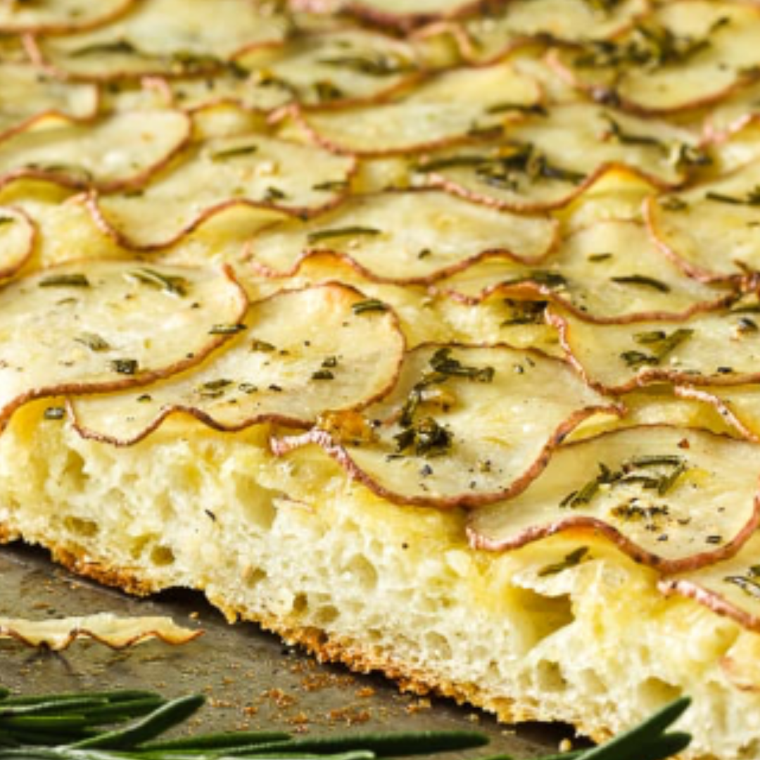 Rustic potato rosemary focaccia bread with garlic and crushed red pepper, sliced potatoes on top