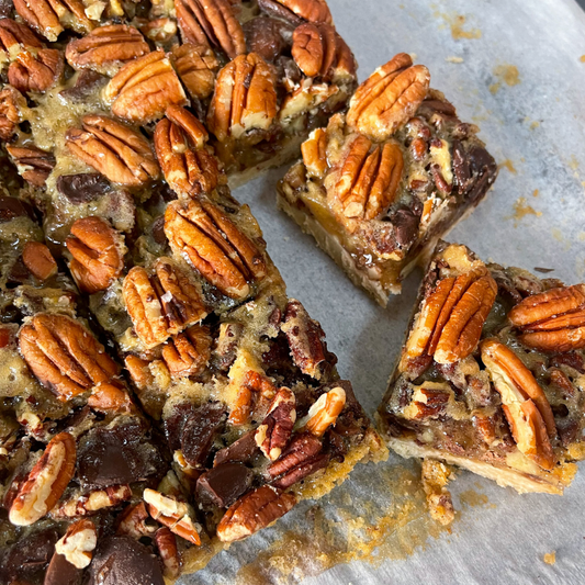 Thanksgiving Treat Feast dessert box with pumpkin blondie, oatmeal cookie sandwich, frangipane tartlet, pecan bar, toffee bar, and apple cake for local pickup at Shift